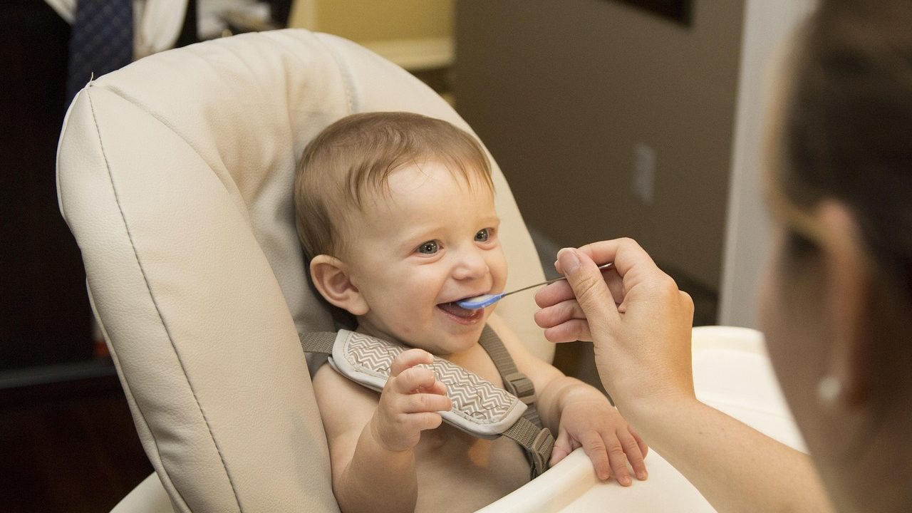 Ek gıdaya başlayan bebek ve mama sandalyesinde beslenme süreci