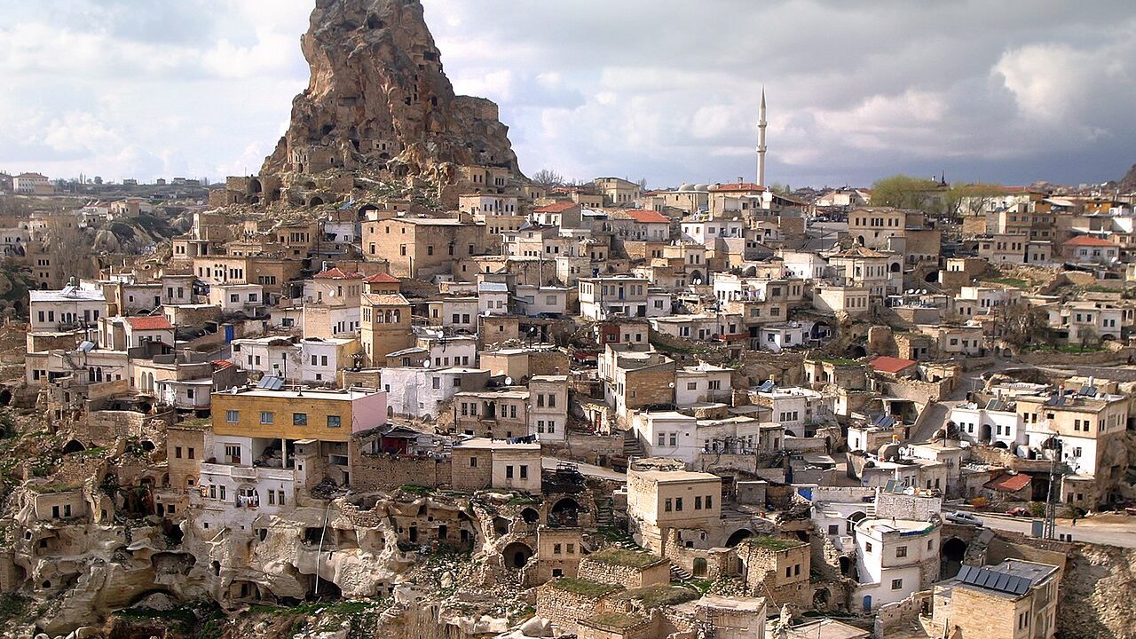 Kapadokya'da gün doğarken uçan sıcak hava balonları ve peri bacaları manzarası